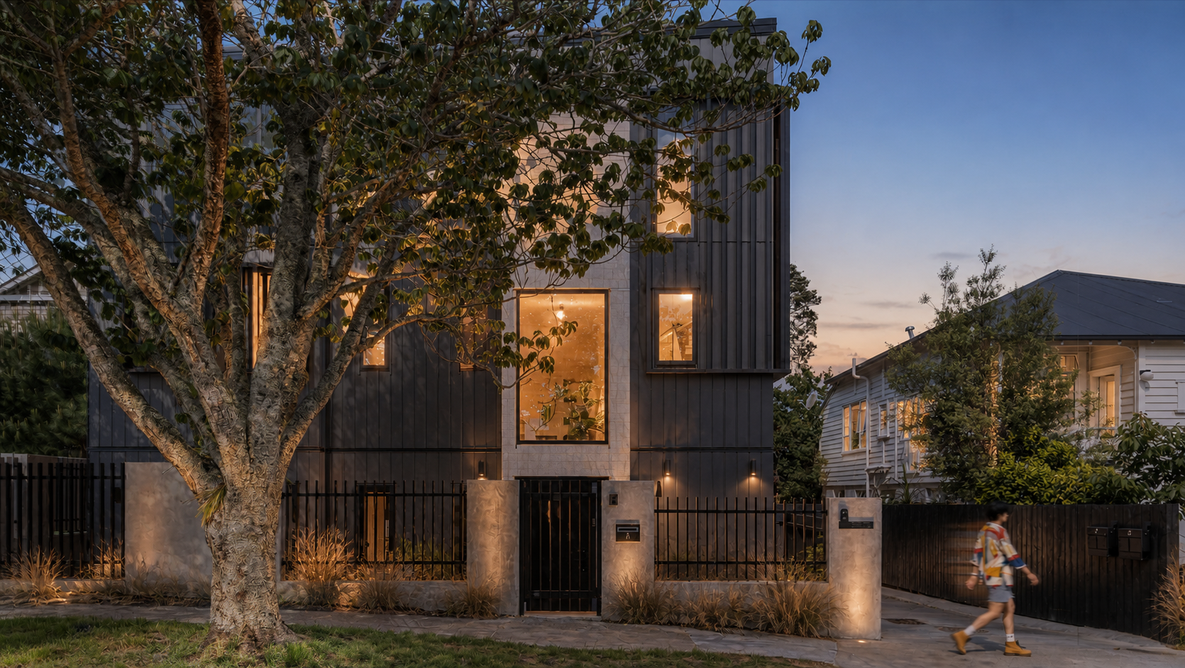 Mt Eden residential project at dusk with a mature street tree and warm interior light.